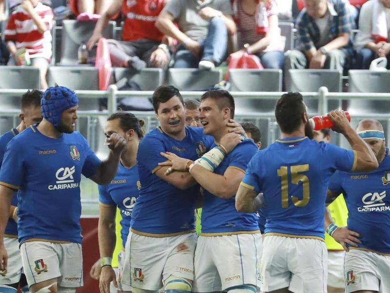 Italy's Jake Polledri (centre right, congratulated after scoring against Japan) has had to retire. (AP PHOTO)